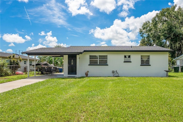 view of front of property with a front yard and a carport