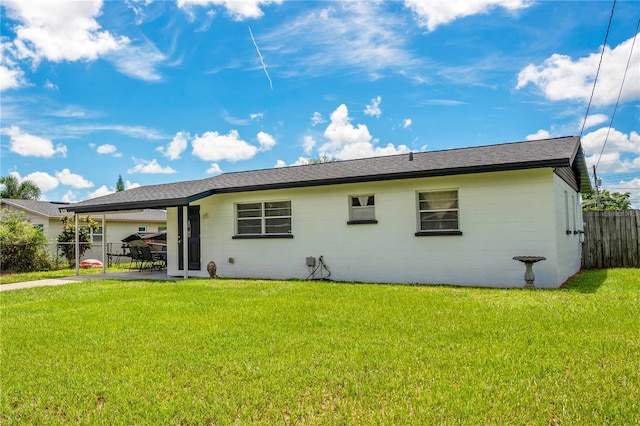 back of property featuring a patio area and a lawn