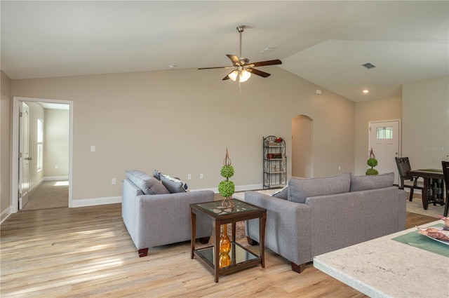 living room with ceiling fan, lofted ceiling, a wealth of natural light, and light wood-type flooring