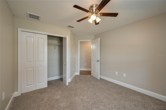 unfurnished bedroom featuring light carpet, a closet, and ceiling fan