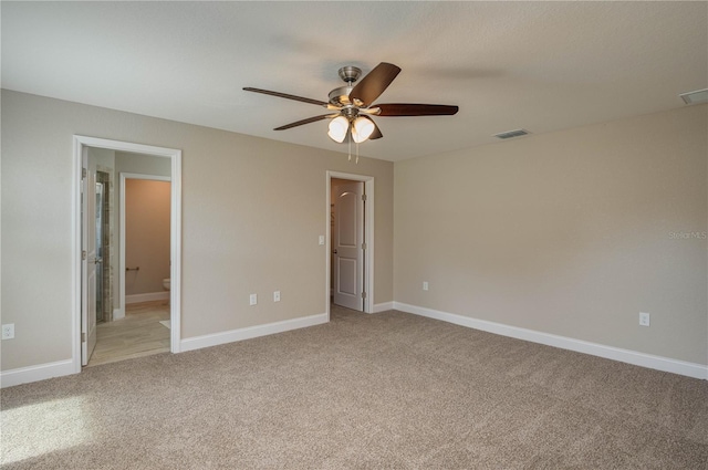 unfurnished bedroom featuring ceiling fan, ensuite bathroom, and light carpet