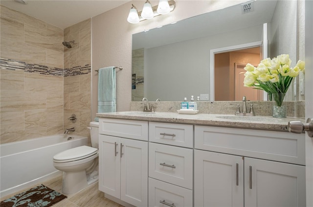 full bathroom with vanity, tiled shower / bath combo, and toilet