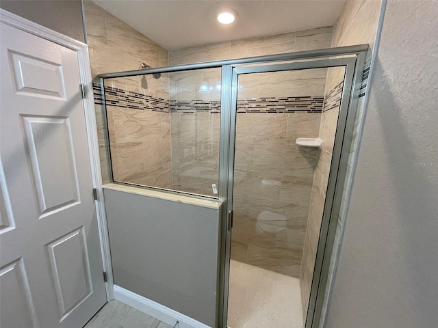 bathroom featuring a shower with door