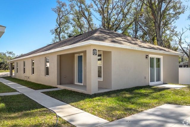 back of property with a lawn and a patio