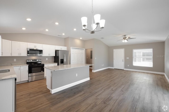 kitchen with dark hardwood / wood-style flooring, stainless steel appliances, pendant lighting, white cabinets, and a center island