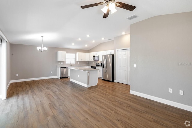 kitchen with appliances with stainless steel finishes, hardwood / wood-style flooring, a center island, white cabinetry, and hanging light fixtures