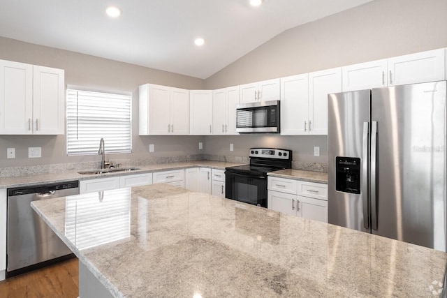 kitchen with light stone countertops, sink, white cabinetry, and stainless steel appliances