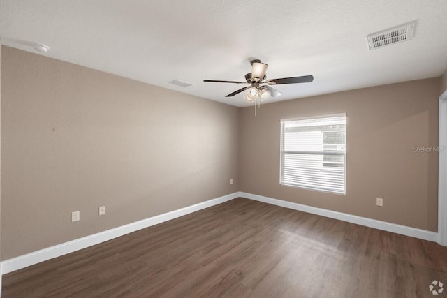 empty room with ceiling fan and dark hardwood / wood-style floors