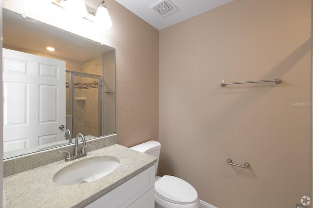 bathroom featuring vanity, toilet, and an enclosed shower