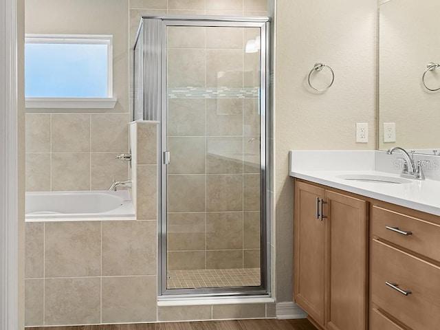 bathroom with hardwood / wood-style floors, vanity, and shower with separate bathtub