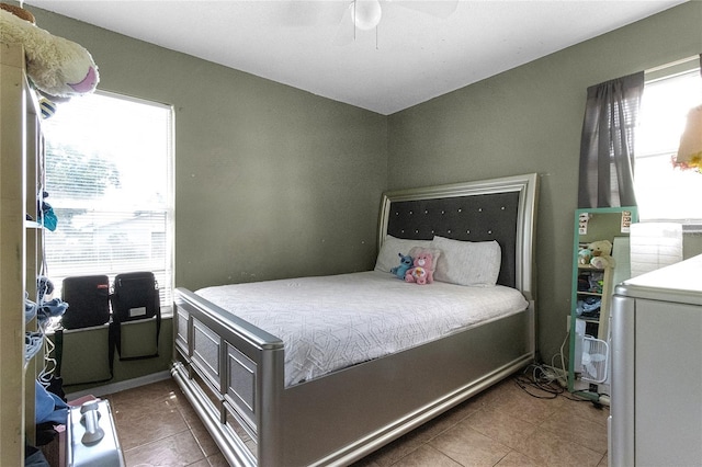 tiled bedroom featuring ceiling fan