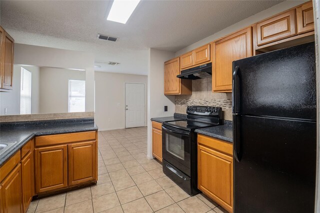 kitchen with a textured ceiling, black appliances, decorative backsplash, and light tile patterned flooring