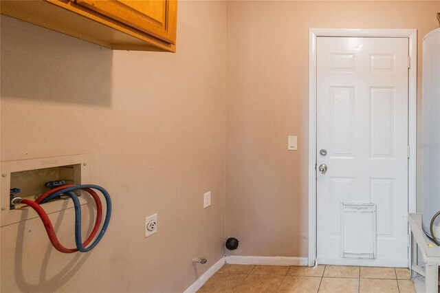 washroom featuring cabinets, washer hookup, and light tile patterned flooring