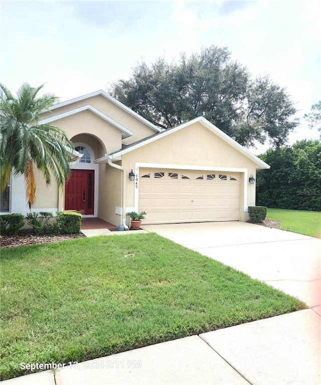 single story home featuring a garage and a front yard