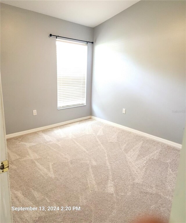 unfurnished room featuring light colored carpet