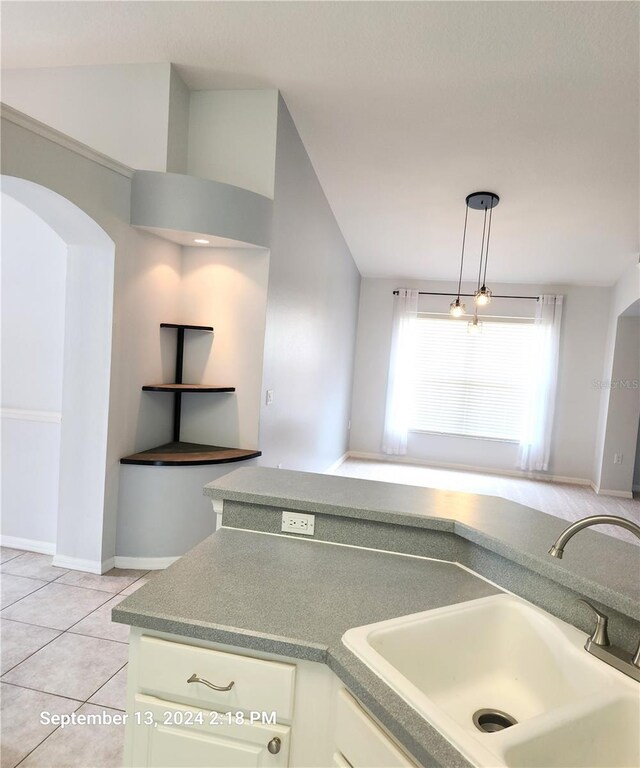 kitchen featuring light tile patterned floors, sink, and hanging light fixtures