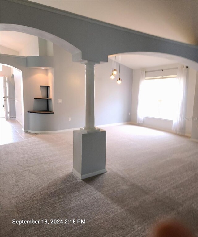 carpeted empty room with vaulted ceiling