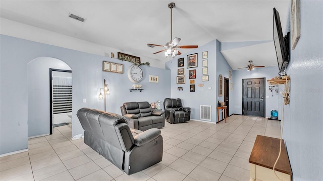 living area with visible vents, arched walkways, light tile patterned flooring, and a ceiling fan