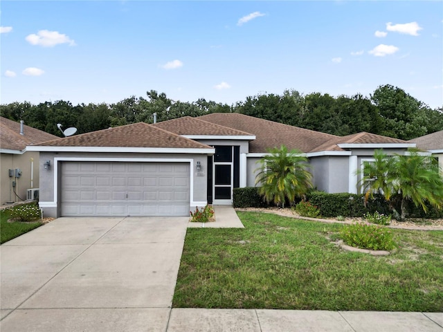 single story home featuring a garage and a front lawn