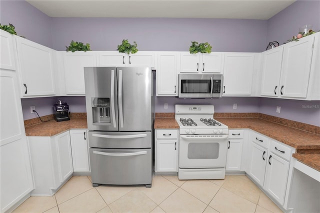 kitchen with light tile patterned floors, white cabinetry, and stainless steel appliances