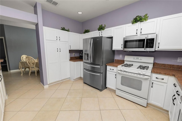 kitchen with white cabinets, appliances with stainless steel finishes, and light tile patterned floors