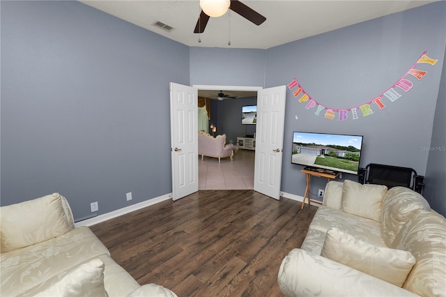 living room with ceiling fan and dark hardwood / wood-style flooring