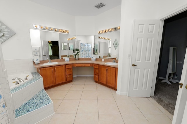 bathroom with vanity, tiled tub, and tile patterned floors