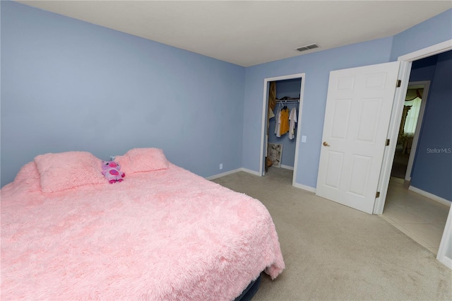 carpeted bedroom with a walk in closet and a closet