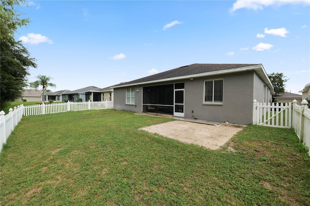 back of property with a lawn and a patio