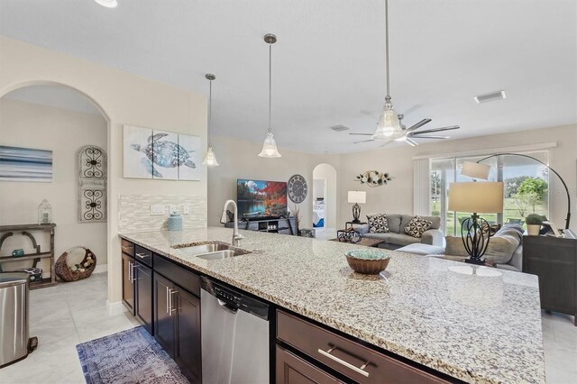 kitchen with visible vents, arched walkways, open floor plan, stainless steel dishwasher, and a sink