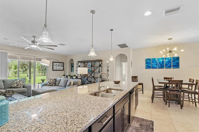 kitchen featuring arched walkways, pendant lighting, and a sink