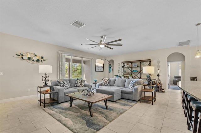 living room with visible vents, arched walkways, and a ceiling fan