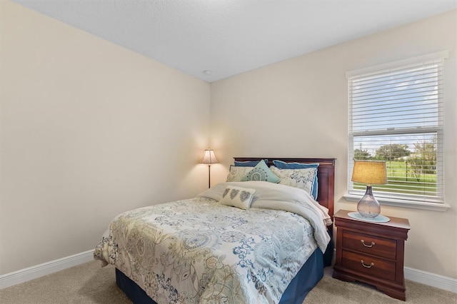 bedroom with light carpet and baseboards