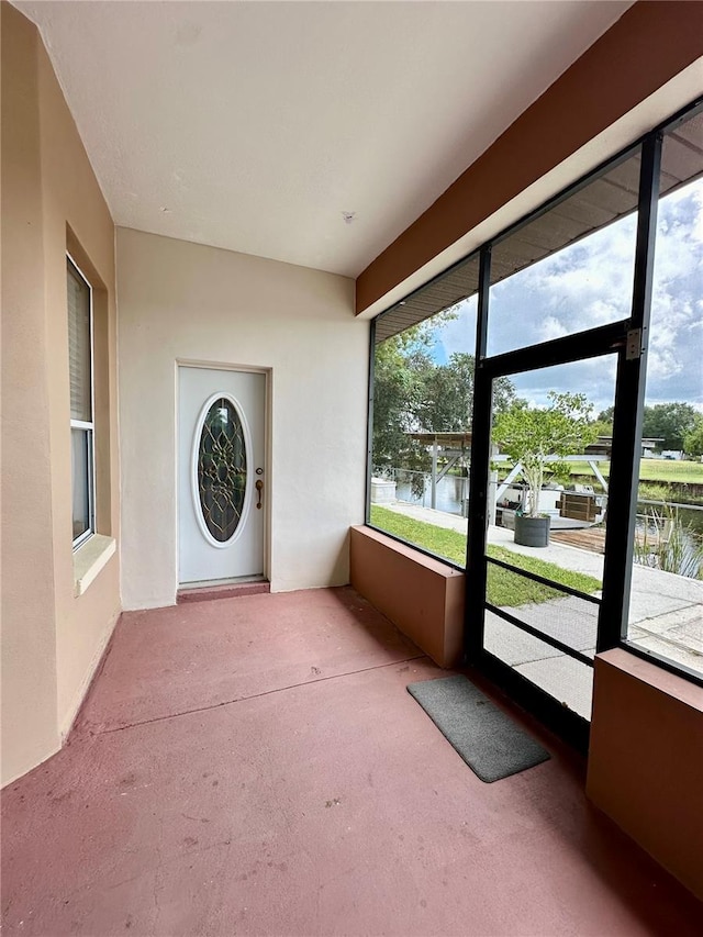 unfurnished sunroom featuring a water view