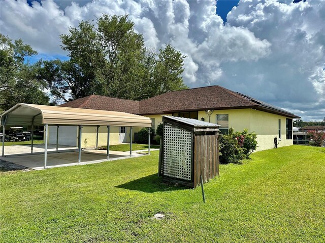 view of side of property with a carport and a lawn