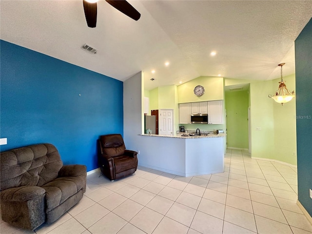 unfurnished living room featuring light tile patterned floors, ceiling fan with notable chandelier, and vaulted ceiling