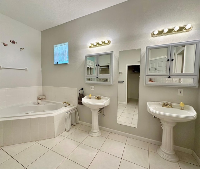 bathroom featuring tiled bath, a textured ceiling, and tile patterned floors