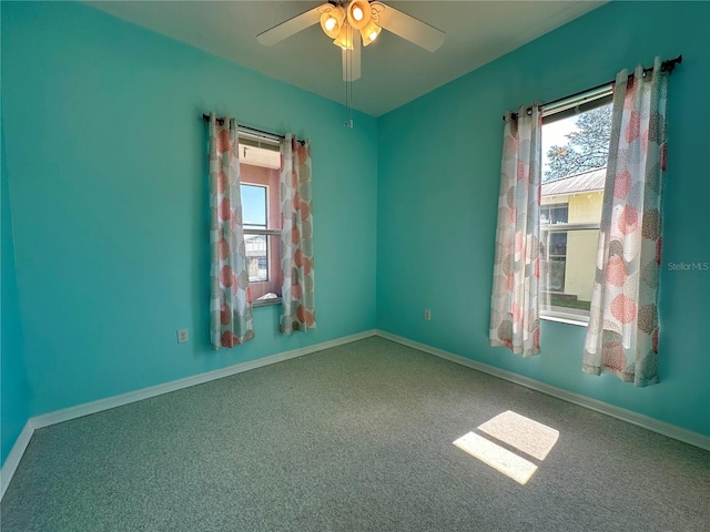 empty room featuring a wealth of natural light, baseboards, and a ceiling fan