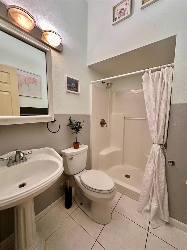 full bathroom featuring toilet, tile patterned floors, a shower with curtain, and baseboards