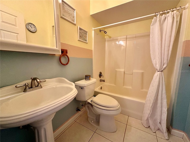 bathroom with tile patterned flooring, baseboards, toilet, shower / bathtub combination with curtain, and a sink