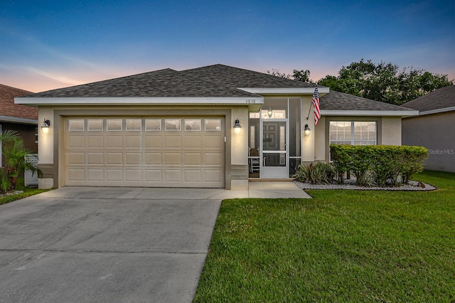 view of front of property with a yard and a garage