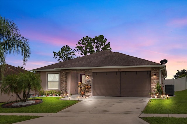 ranch-style home with a front lawn, stone siding, fence, concrete driveway, and a garage