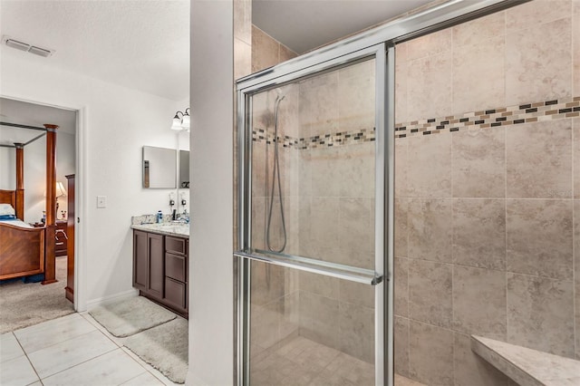 bathroom with tile patterned floors, vanity, and walk in shower