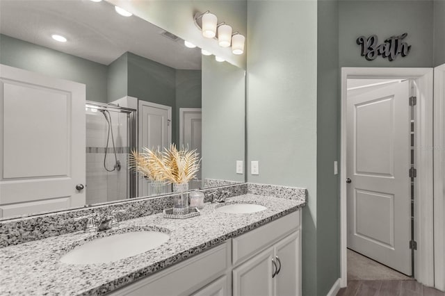 bathroom with vanity, hardwood / wood-style floors, and an enclosed shower