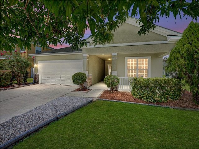 view of front facade with a yard and a garage