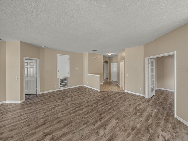 unfurnished living room featuring a textured ceiling and hardwood / wood-style floors