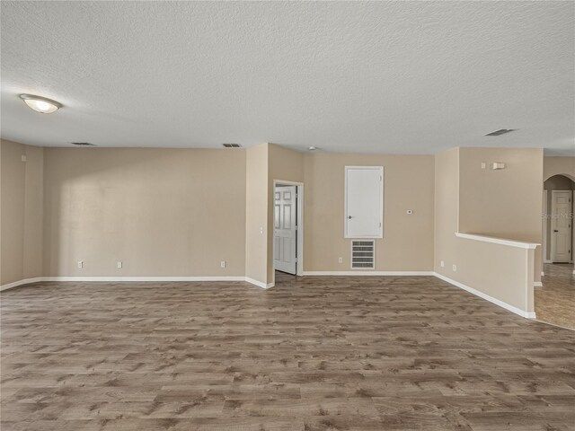 unfurnished room featuring hardwood / wood-style flooring and a textured ceiling