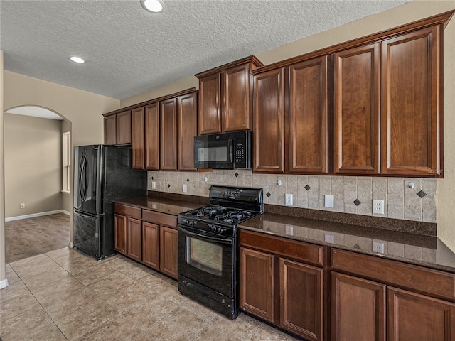 kitchen with black appliances, dark stone countertops, tasteful backsplash, and a textured ceiling