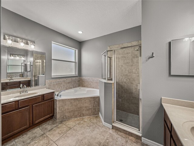 bathroom featuring a textured ceiling, vanity, independent shower and bath, and tile patterned floors