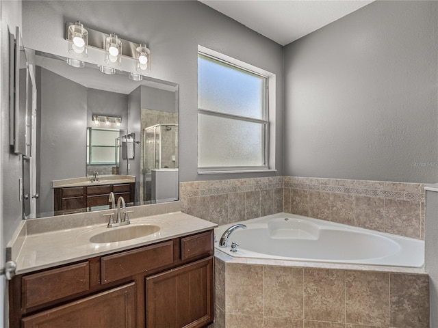 bathroom featuring vanity and independent shower and bath